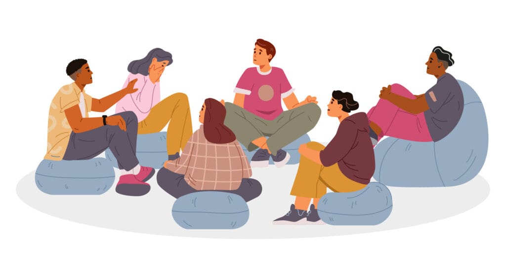 Group Therapy | group of racially diverse young people sitting on bean bag chairs in a group therapy setting.